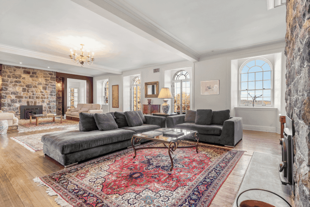 Salon au Manoir Davis avec deux divans de couleur crème et un divan en coin de couleur grise et deux tables