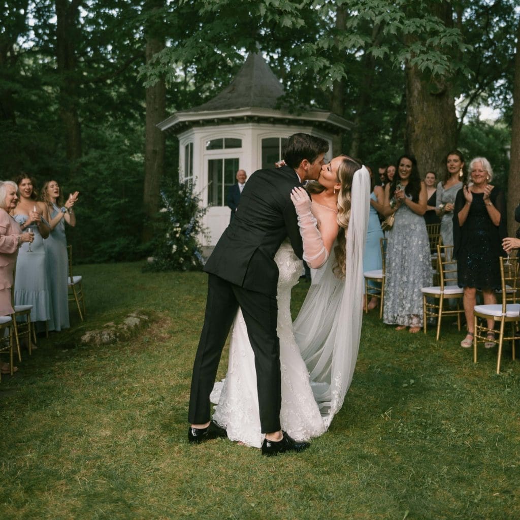 Nouveaux mariés s'embrassant dans la cour du Manoir Maplewood