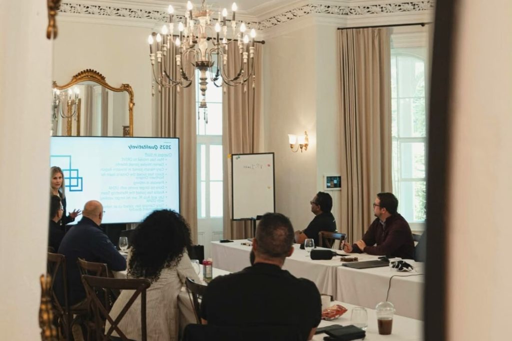 Séance de travail de l’équipe DSMA au Manoir Maplewood, lors du lac-à-l’épaule 2025, dans une salle de conférence élégante alliant patrimoine et technologie moderne.