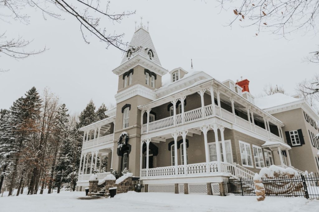 Façade manoir maplewood enneigé au lever du jour, ambiance hivernale élégante pour team building